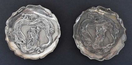 A pair of Chinese Export silver dishes decorated with dragons, character mark to base, diameter 9.