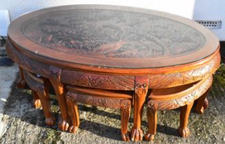 A modern carved Chinese style nest of coffee tables, comprising main oval coffee table, width 126cm,