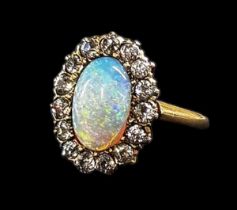 A 14ct yellow gold opal and diamond ring, set with large central opal surrounded by fifteen small