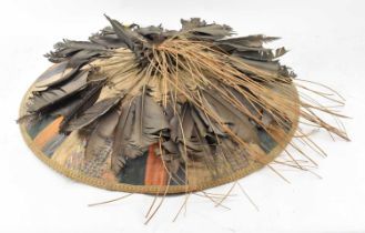 A Southeast Asian straw wide brimmed hat with adjustable chin strap and feather decoration to the