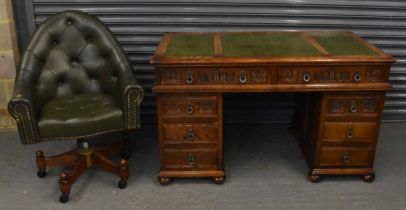 A reproduction carved oak twin pedestal desk with green leather gilt tooled inset top and pair of