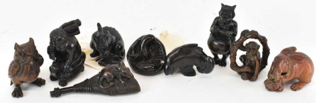 A group of nine carved hardwood netsukes including a moneky, an owl, a rabbit, a lady etc.