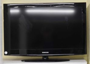 A Samsung 31'' television with three remote controls and Bosch Maxx 6 washing machine.