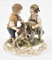 A late 19th century porcelain figural group, depicting young boy and girl with dogs, with cross