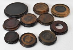 A group of ten Chinese carved hardwood circular display stands.