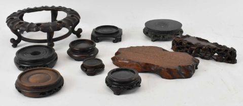 A group of nine Chinese carved hardwood stands and a Chinese carved hardstone stand (10).