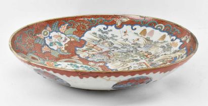A 19th century Japanese Imari decorated bowl with panels of hand painted figures on a red ground,
