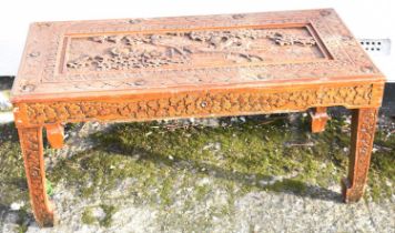 A modern Chinese carved coffee table decorated with peacock amongst foliage, top measures 101 x