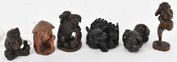 A group of six carved hardwood netsukes including dogs, dragon, owl, moneky etc.