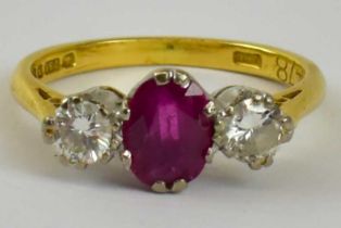 An 18ct yellow gold three stone ruby and diamond ring set with central ruby between two diamonds,