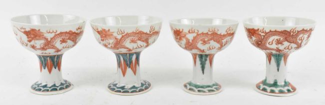 A set of four Chinese Republic period Famille Rose stem cups, decorated with orange dragons,