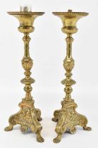 A pair of brass candlesticks, with cherub decoration to the base, height 36cm.