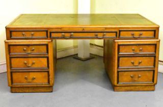 A 19th century oak partner's desk with gilt tooled leather insert top, drawers and cupboard doors,