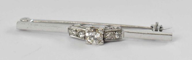 A white metal diamond set bar brooch, the central diamond approx 0.25ct, and four smaller