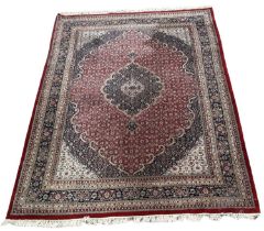 A large Persian red ground floral decorated carpet with geometric border, 400 x 295cm.