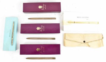 A group of five ballpoint pens; three silver examples by Asprey in their pouches and boxes, a