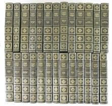 A group of approximately twenty-five green leather bound Charles Dickens books.