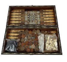 A Middle Eastern mother of pearl inlaid games box containing modern chess pieces and draughts