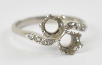 A platinum dress ring set with four small diamonds to each shoulder, with the two large central