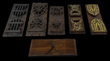 Two brass bound folding bookends, a walnut folding bookend and three heavily carved folding bookends