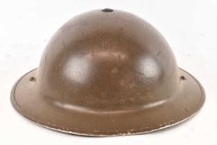 A WWII period helmet with canvas chin strap and leather insert.