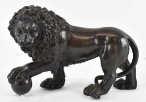 A bronze model of a lion with a ball in its left claw, length 22cm, height 15cm. Condition Report: