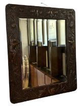 An Arts and Crafts copper framed wall mirror with floral decoration and nude female motifs, 80 x
