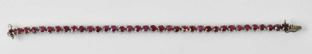 A white metal ruby set tennis bracelet, rubies totalling approx 3.5ct, length 16.5cm, approx 11.5g.