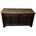 An 18th century carved oak coffer, with hinged lid and candle holder, width 142cm.