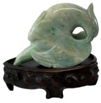 A Chinese carved green hardstone of a bird on associated carved hardwood base, height of hardstone