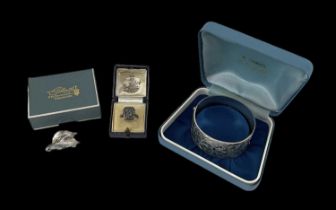 A hallmarked silver bangle, Birmingham 1976, a small silver leaf brooch and a silver marcasite ring,