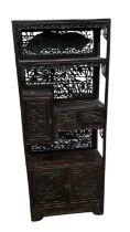 A Chinese carved hardwood and ebonised display cabinet, with two drawers above pair of cupboard