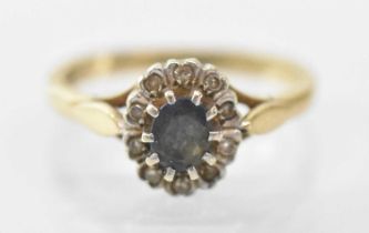 A 9ct yellow gold sapphire and diamond set ring, the central sapphire surrounded by multiple small
