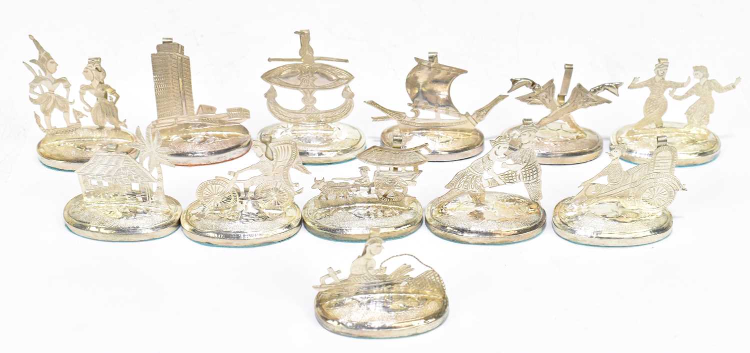A set of twelve Thai white metal menu holders, with simple spring clasp back and loaded oval bases