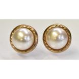 A pair of yellow metal and pearl set earrings, combined approx 0.9g.