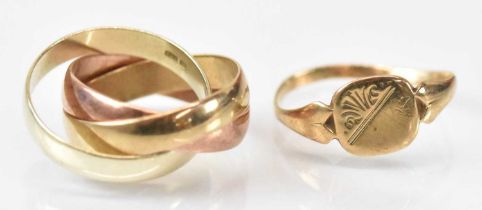 A group of three 9ct yellow gold interlocked rings formed to make one ring, size L/M, and a