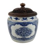 An 18th century Kangxi period blue and white decorated jar with carved hardwood cover, double ring