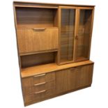 A teak mid century wall unit, with pair of glazed doors and fall front cupboard above pair of