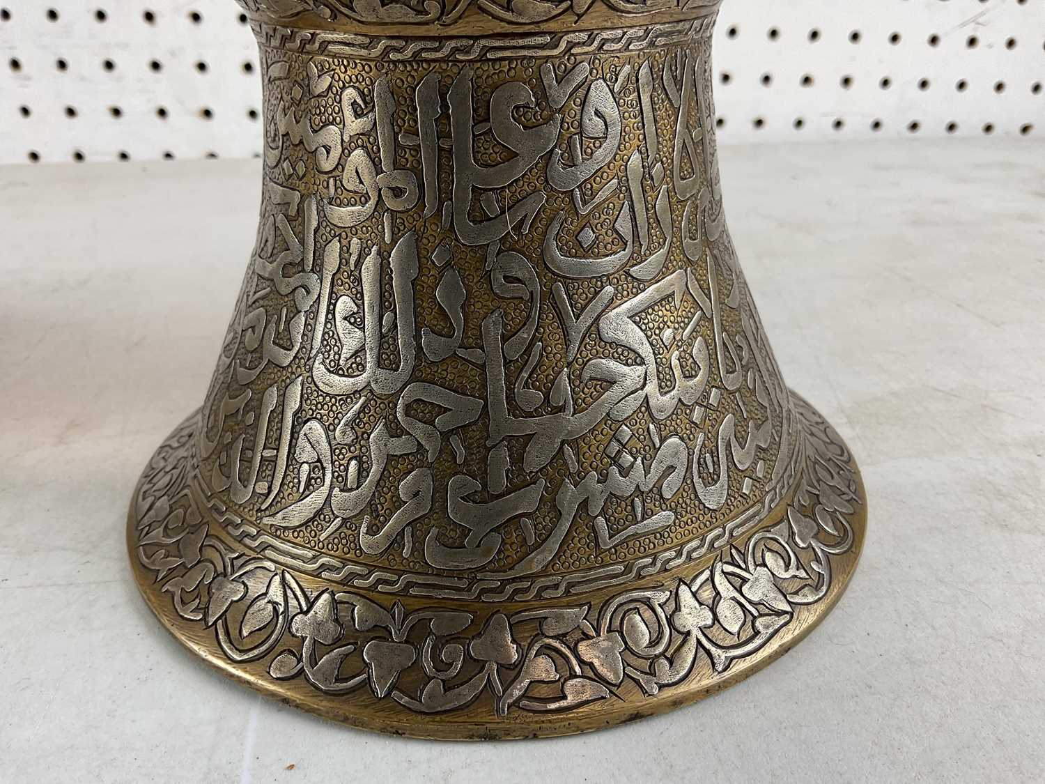 A pair of Islamic brass and silver inlaid candlesticks with Arabic calligraphy, height 30cm. - Image 2 of 3
