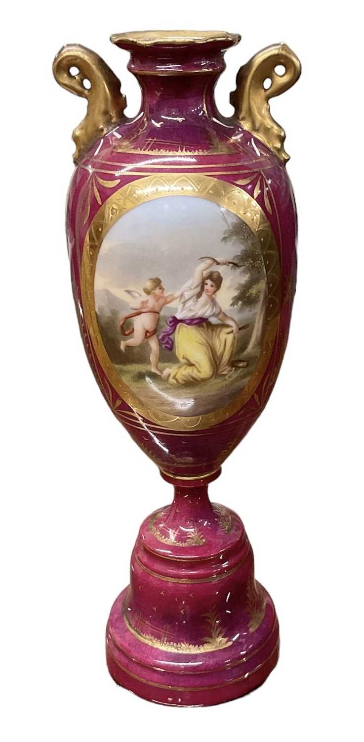 A Vienna porcelain red ground hand painted urn decorated with a cherub playing with a female figure,