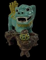 A 20th century Chinese turquoise and yellow glazed Dog of Fo on carved hardwood stand, length approx