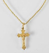 A yellow metal necklace suspending a yellow metal crucifix pendant, combined approx 4.5g.