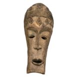 A large African carved mask, height 110cm, width approx 45cm.