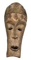 A large African carved mask, height 110cm, width approx 45cm.