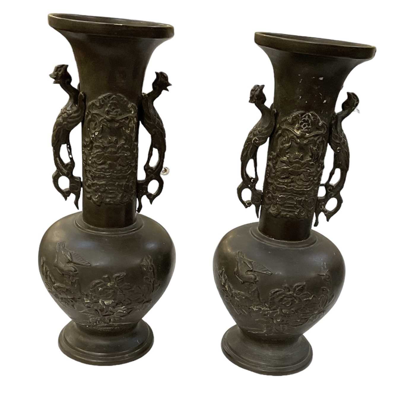 A pair of Japanese bronze Meiji period twin handled vases, the handles modelled as birds and with