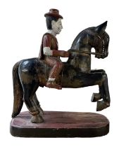A Burmese carved hardwood figure of a man on rearing horse, set with small jewels, width 59cm,
