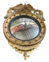 A 19th century convex gilt wood circular wall mirror, with eagle decoration to the top, height