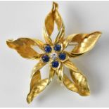 An 18ct yellow gold diamond and sapphire set flower brooch, the central stone approx 0.2ct,