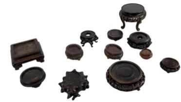 A group of twelve Chinese carved hardwood display stands.