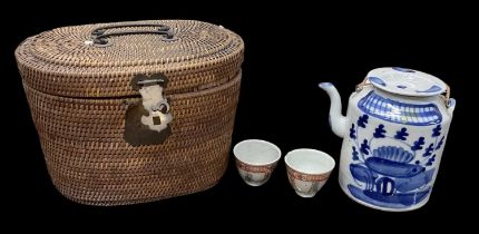 A 20th century Chinese blue and white decorated lidded teapot with pair of tea bowls, contained in